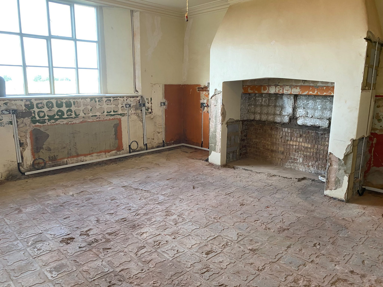 The kitchen stripped back to bare walls and the original brick floor: A country house kitchen, before and after